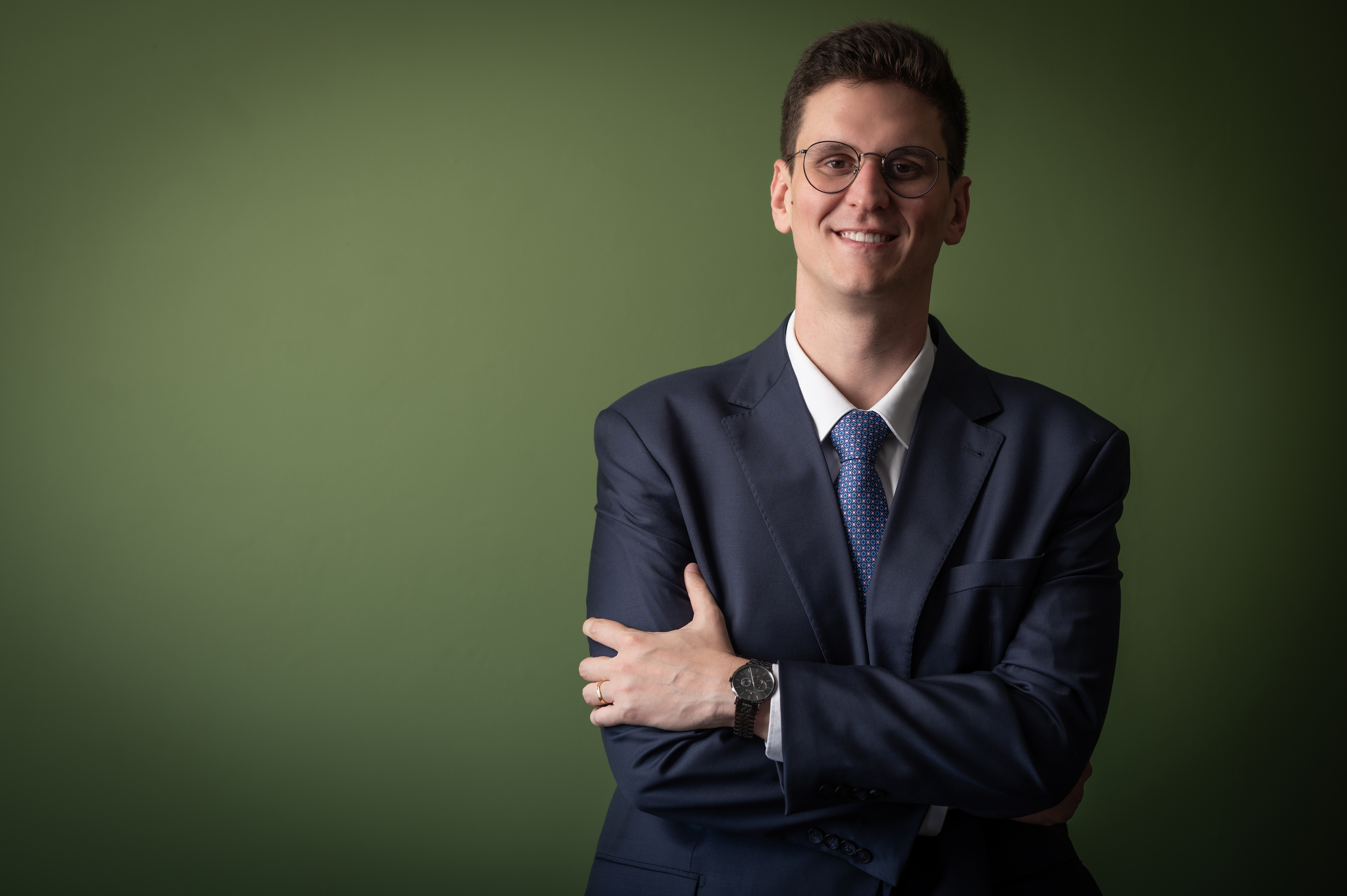 Rafael de Barros Pustrelo — Sócio, braços cruzados sorrindo, fundo verde